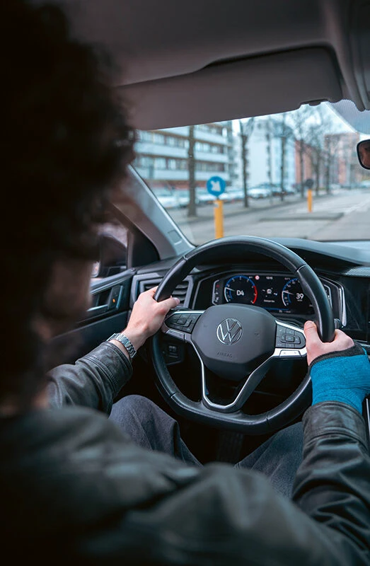 Leerling rijdt zelfstandig door Amsterdam in een Volkswagen lesauto van Rijschool Caland tijdens een proefexamen.
