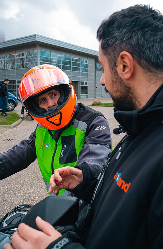 A student and instructor from Driving School Caland are discussing what went right and wrong during the motorcycle lesson in Amsterdam.