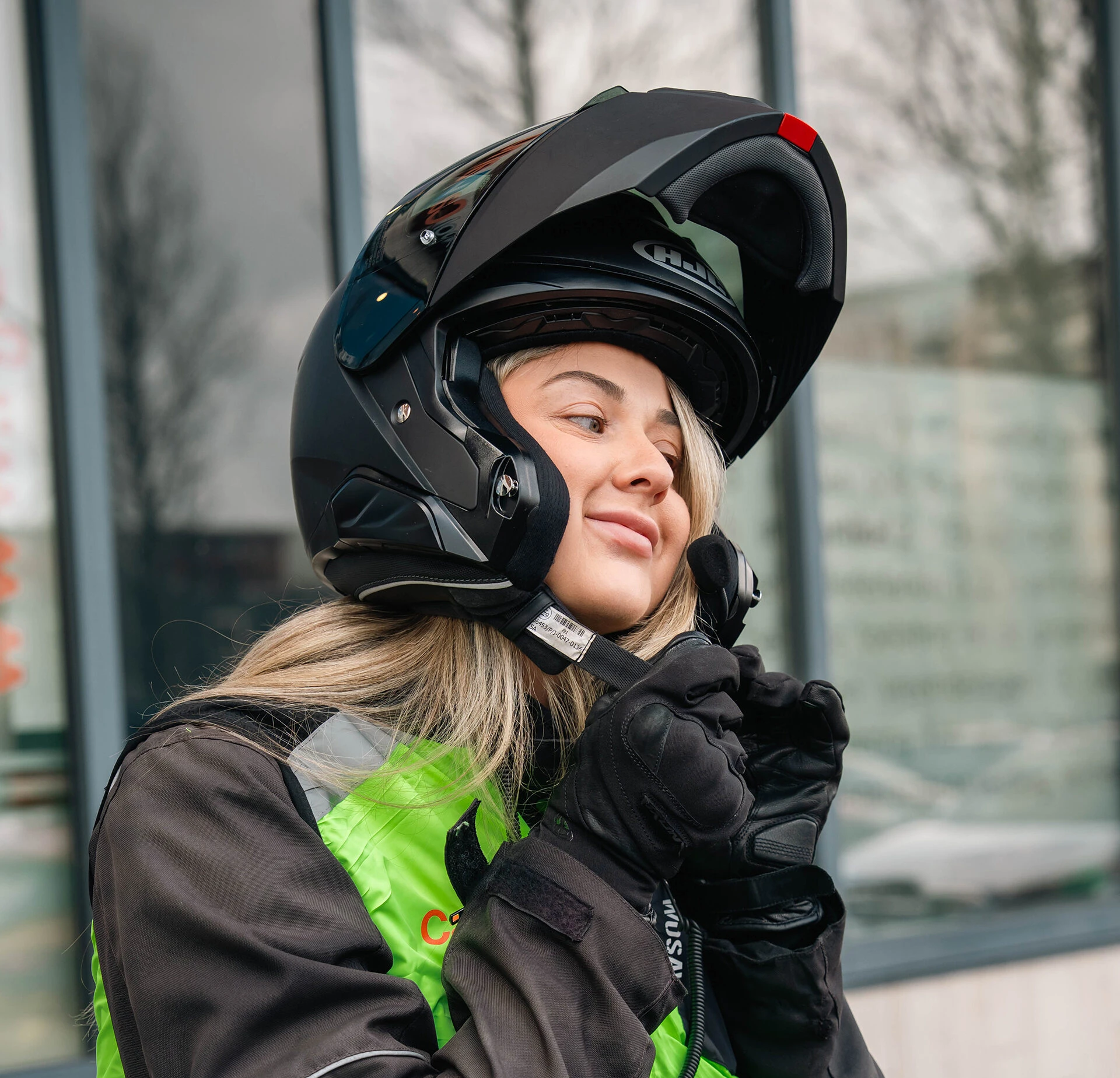 Een leerling van Verkeersschool Caland doet haar helm om voor de motorles, voorzien van motorjas, handschoenen en reflecterend vest, klaar voor een veilige start van het motorseizoen.