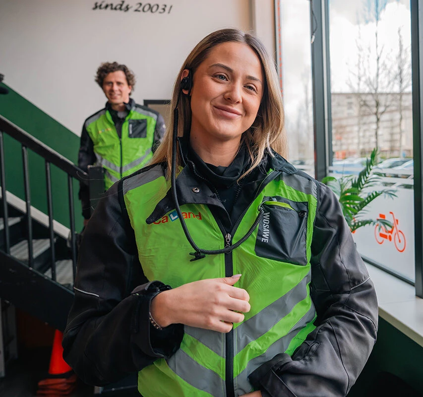 A student of Driving School Caland stands confidently at the Amsterdam branch, ready to start motorcycle lessons for her motorcycle license.