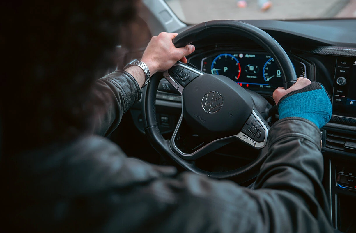 Leerling bestuurt een lesauto met beide handen aan het stuur tijdens een rijles bij Rijschool Caland in Amsterdam, met focus op veilig rijden en voertuigbeheersing.